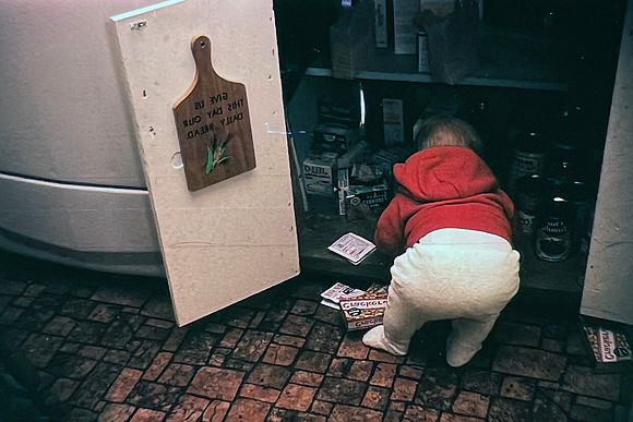 19660500 Erik 8 mos in pulling things out of cupboard